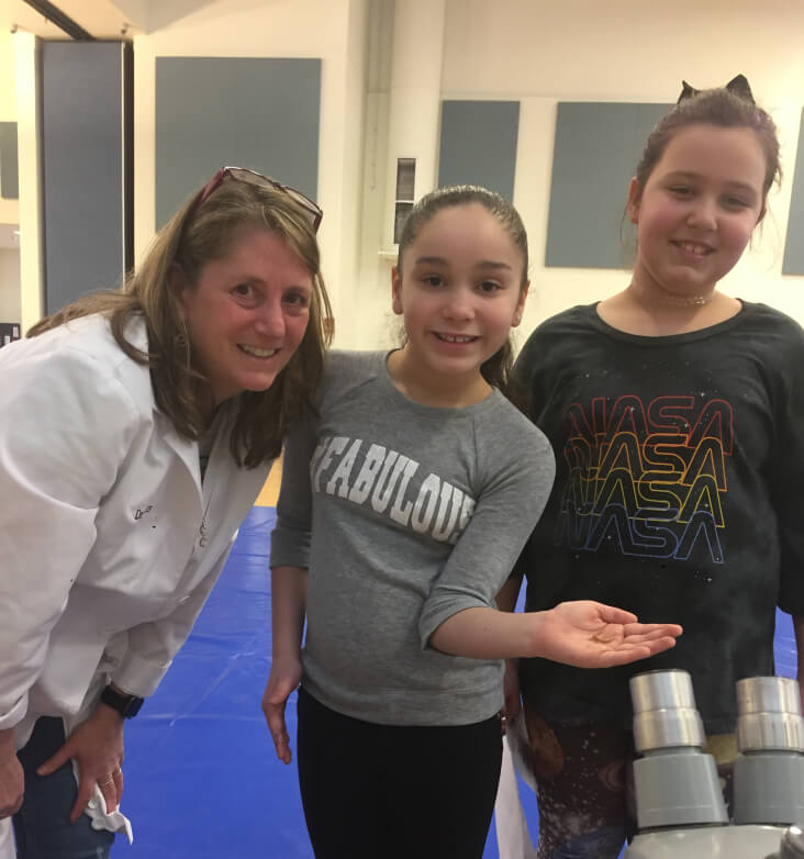 Dr. Bless helping two students with an experiment